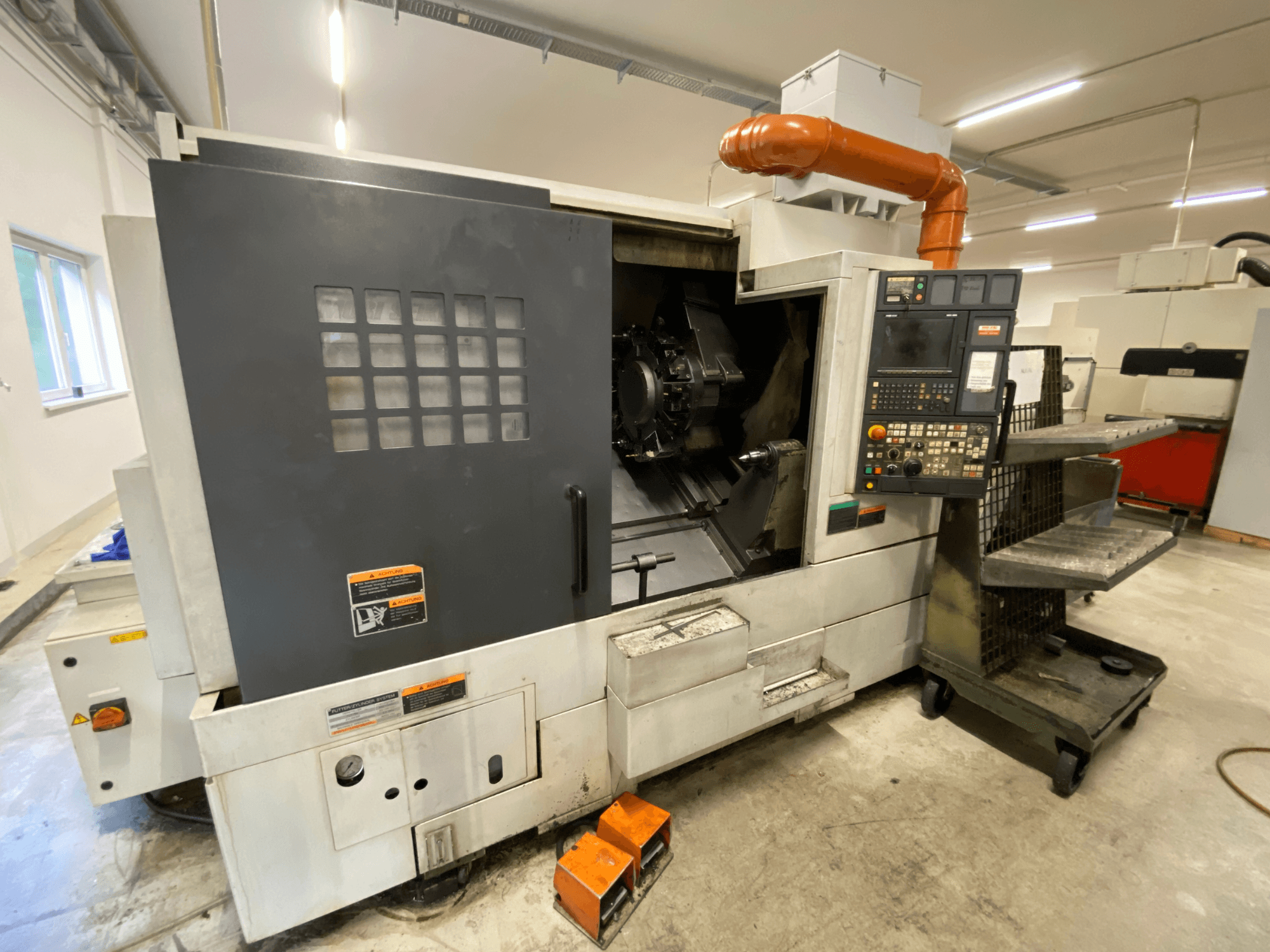 Токарно-фрезерний центр DMG Mori Seiki NL2500Y/700, вид спереду, на якому видно панель управління та деталі кожуха верстата.