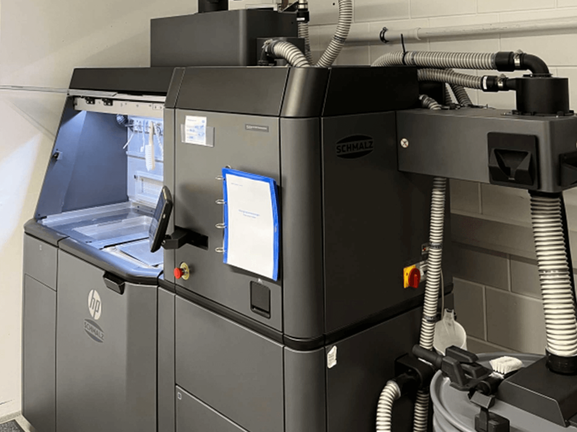 3D-принтер HP Jet Fusion 3D 4200 для друку з пластику, вид збоку, на якому видно панель керування та внутрішні компоненти.