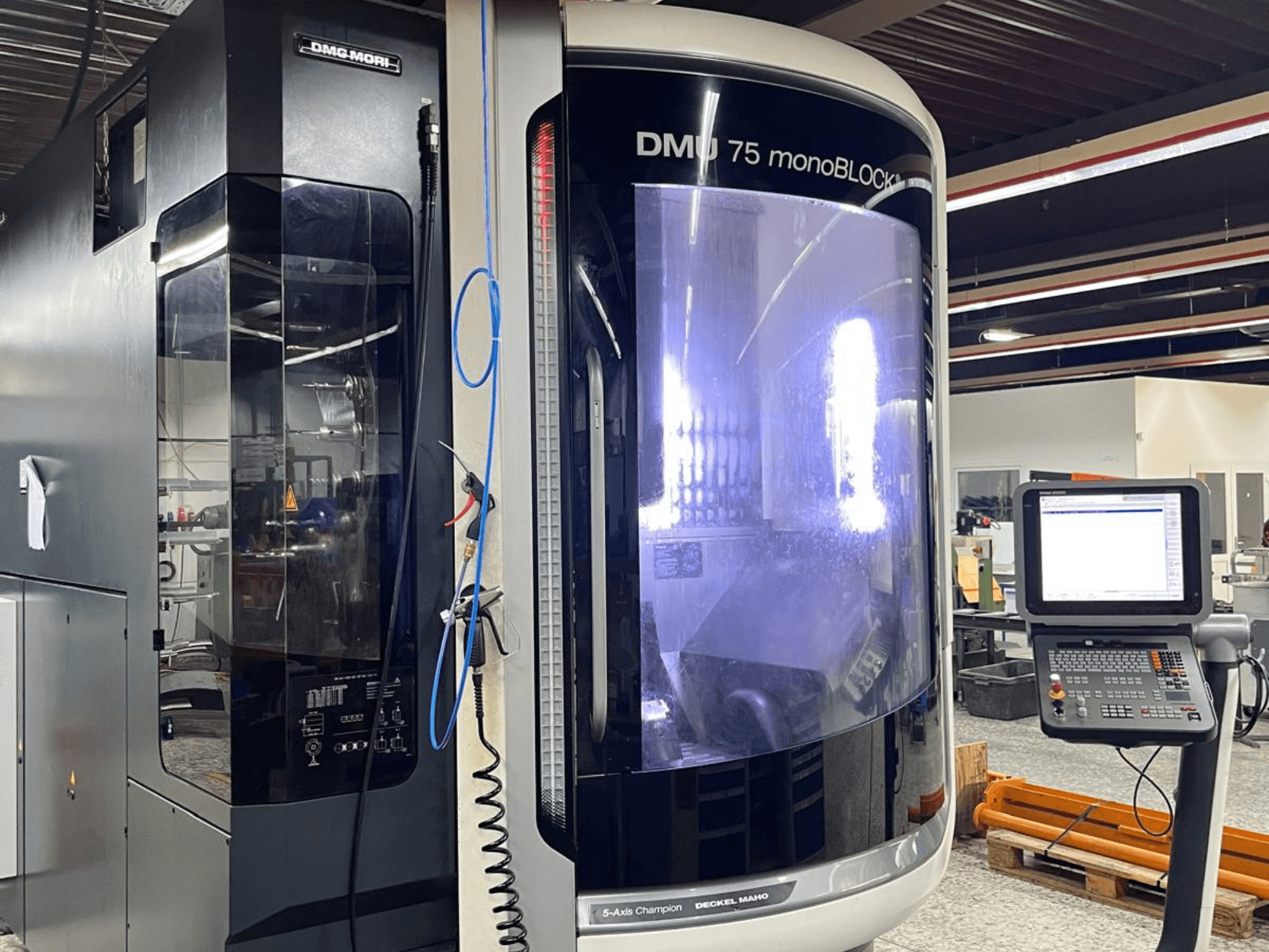 Універсальний обробний центр DMG MORI DMU 75 MonoBlock, вид спереду, панель управління з дисплеєм і характерний корпус.