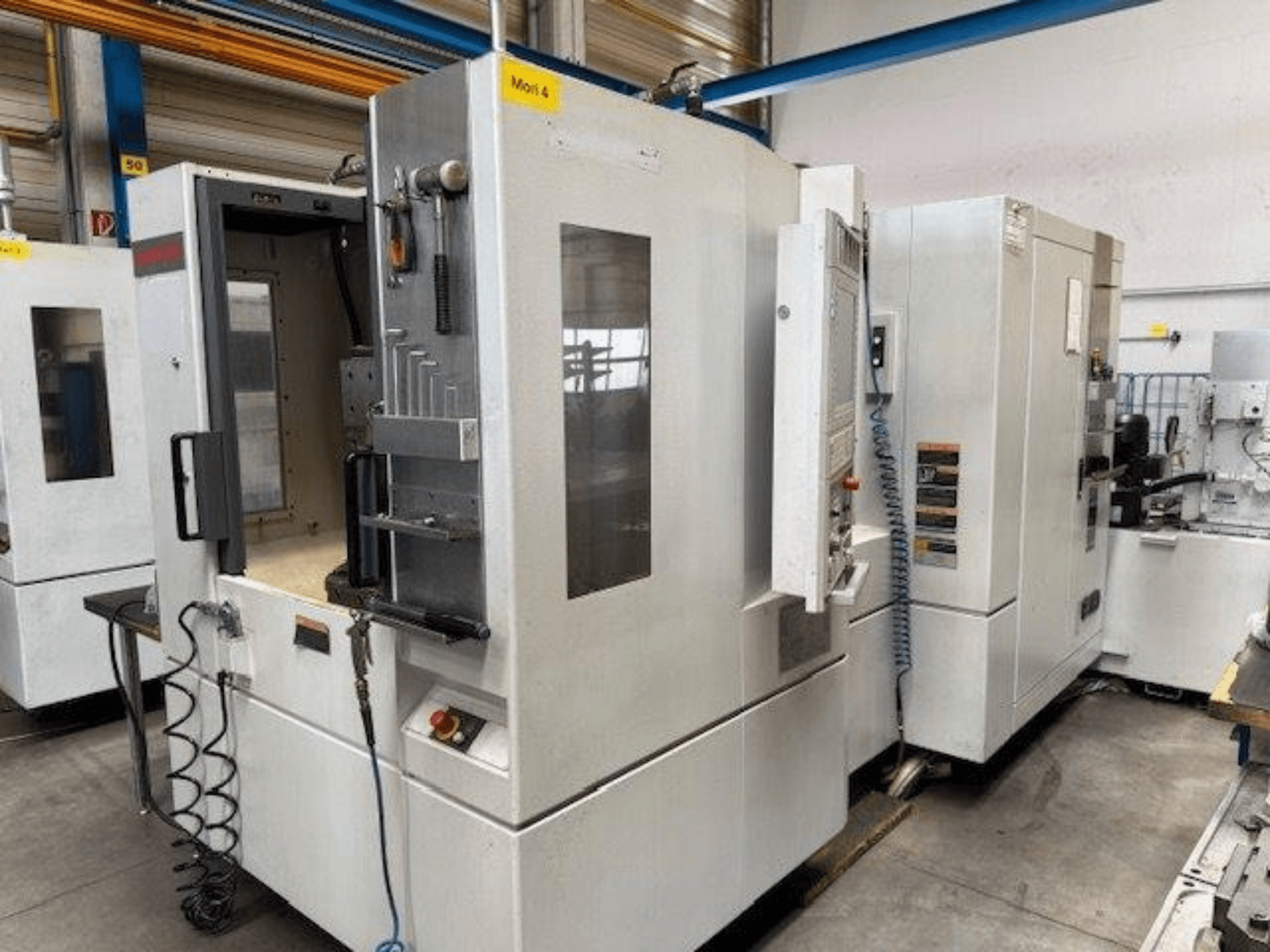 Горизонтальний обробний центр MORI SEIKI NH4000 DCG показаний спереду, з відкритими дверцятами та деталями панелі керування.