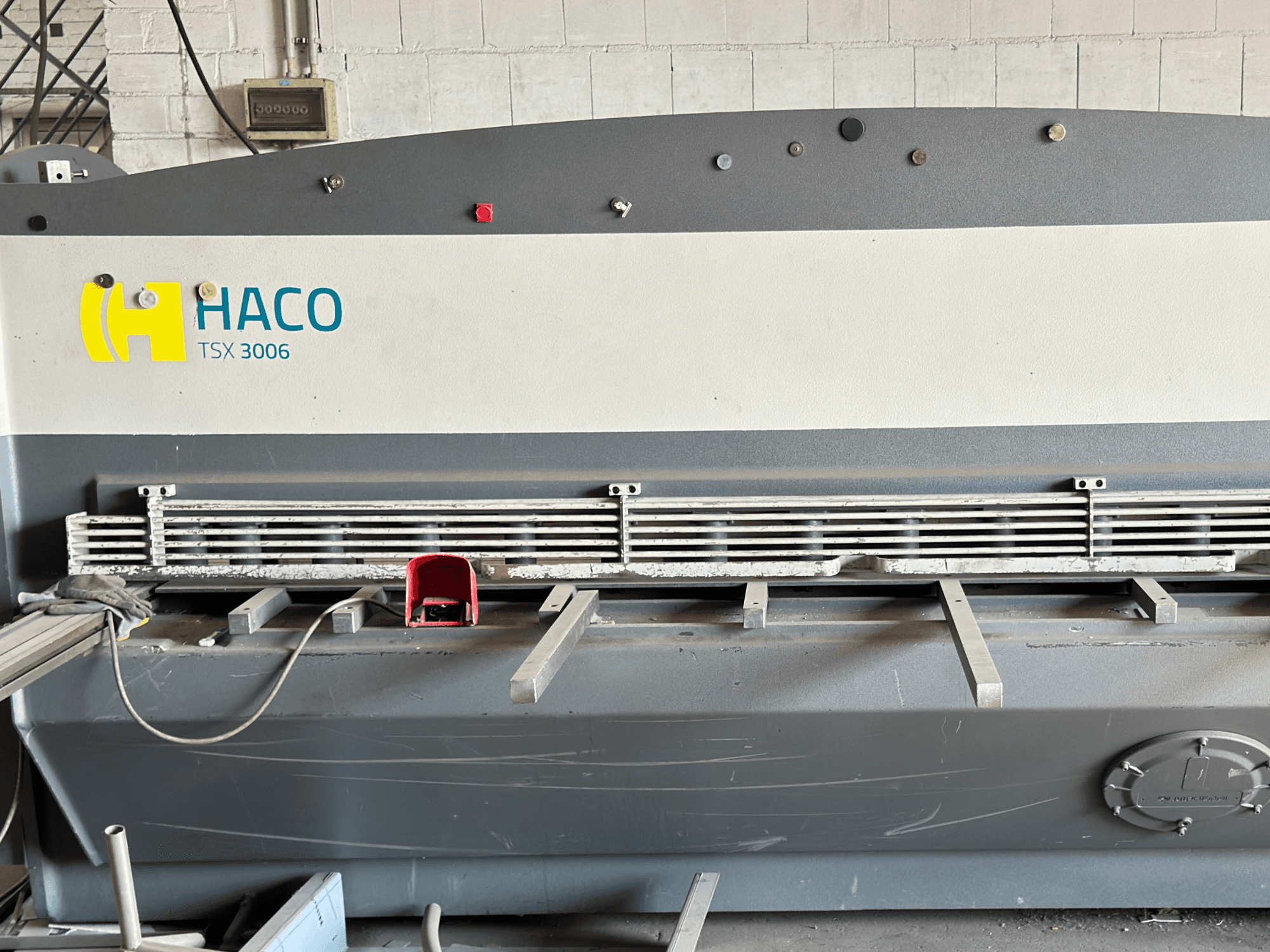 Гідравлічна ножична машина HACO TSX3006 MOT, вид спереду, з металевими ріжучими ножами та панеллю керування, на якій показані деталі роботи.