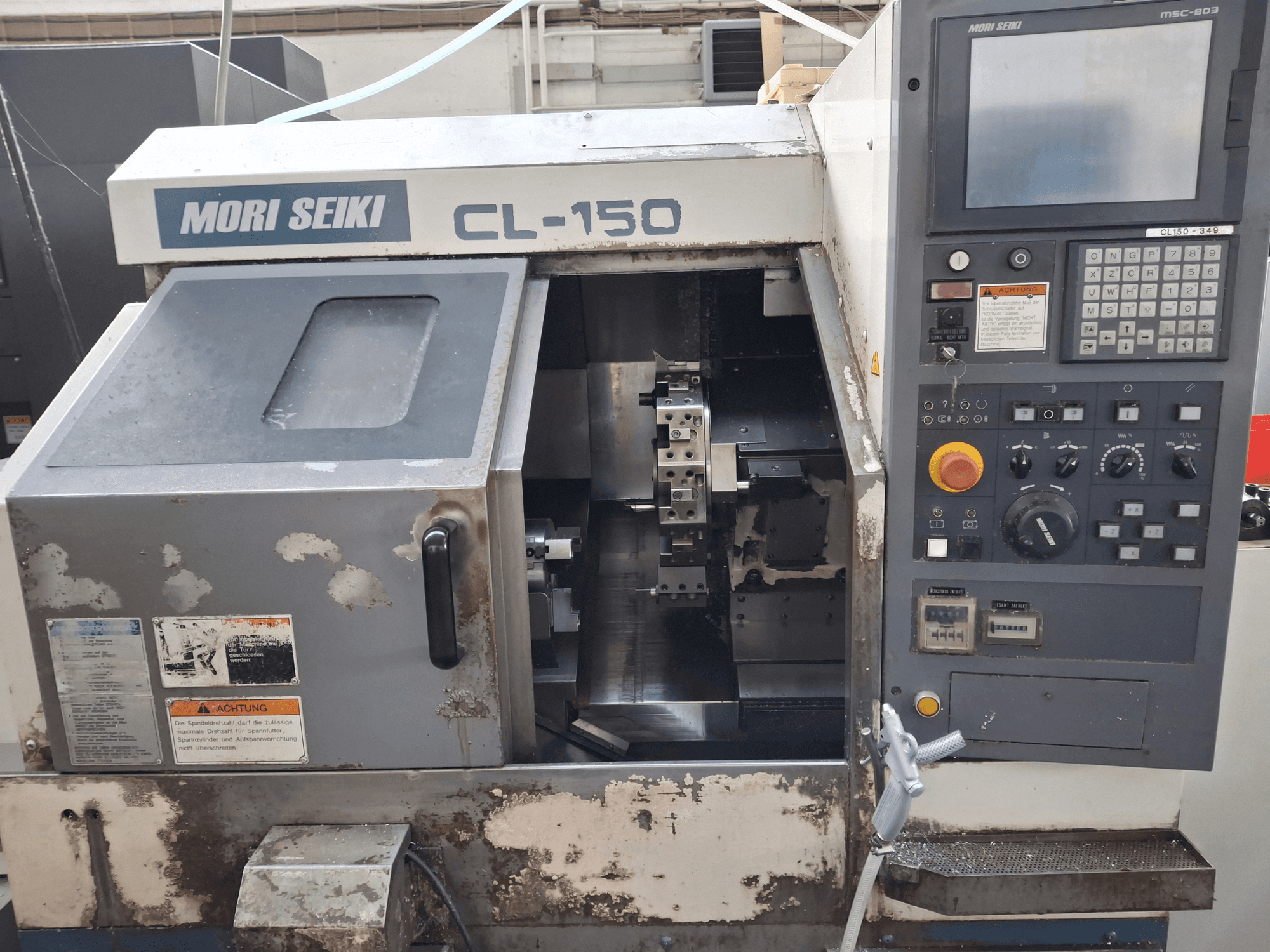 Горизонтальний токарний верстат MORI SEIKI CL-150, вигляд спереду. Показує панель керування, ріжучі інструменти та робочі дисплеї.