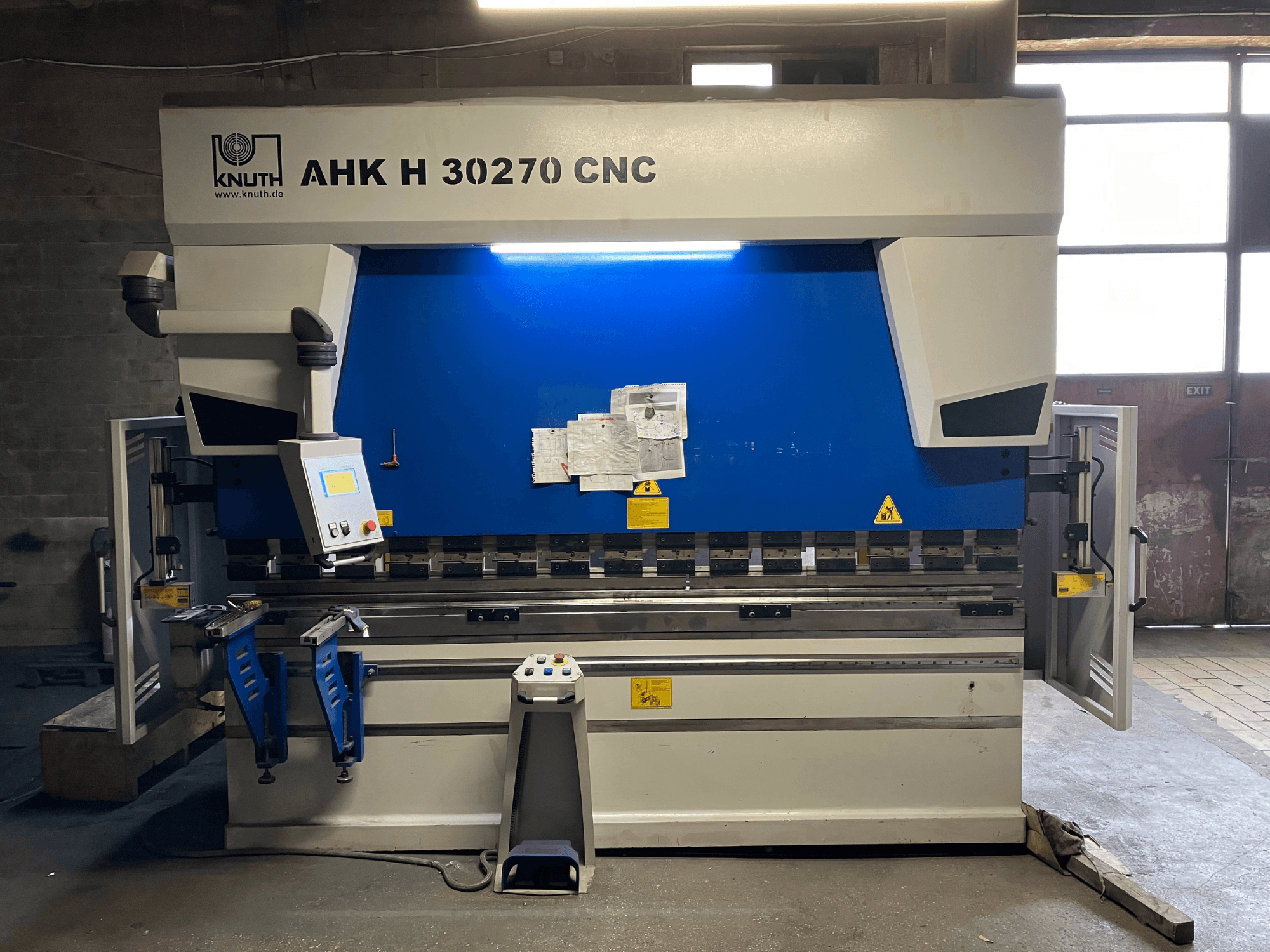 Прес-гибочний верстат KNUTH AHK H 30270 з ЧПУ у цеху, вид спереду, на якому видно панель управління та синьо-біле оформлення, з відкритими бічними дверцятами.