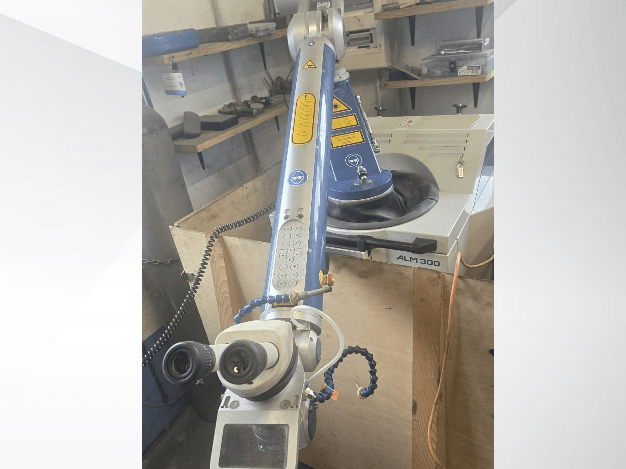 Вигляд спереду лазерного зварювального верстата ALPHA LASER ALM 300 з робочим маніпулятором, оптичними лінзами та панеллю керування.