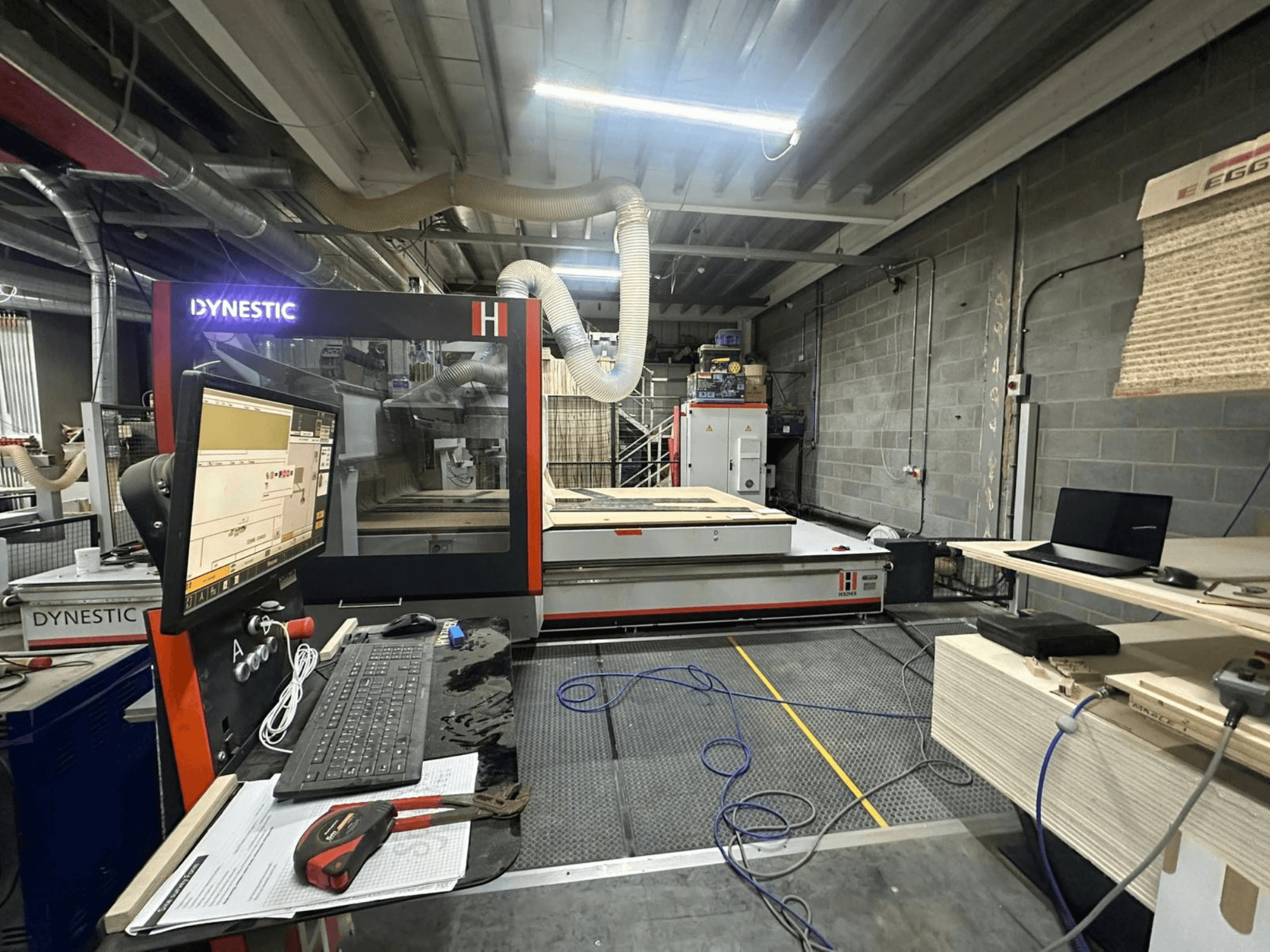 Деревообробний верстат HOLZHER Dynestic 7535 в майстерні, демонструє панель управління, монітор і матеріали на робочому столі, вид спереду.