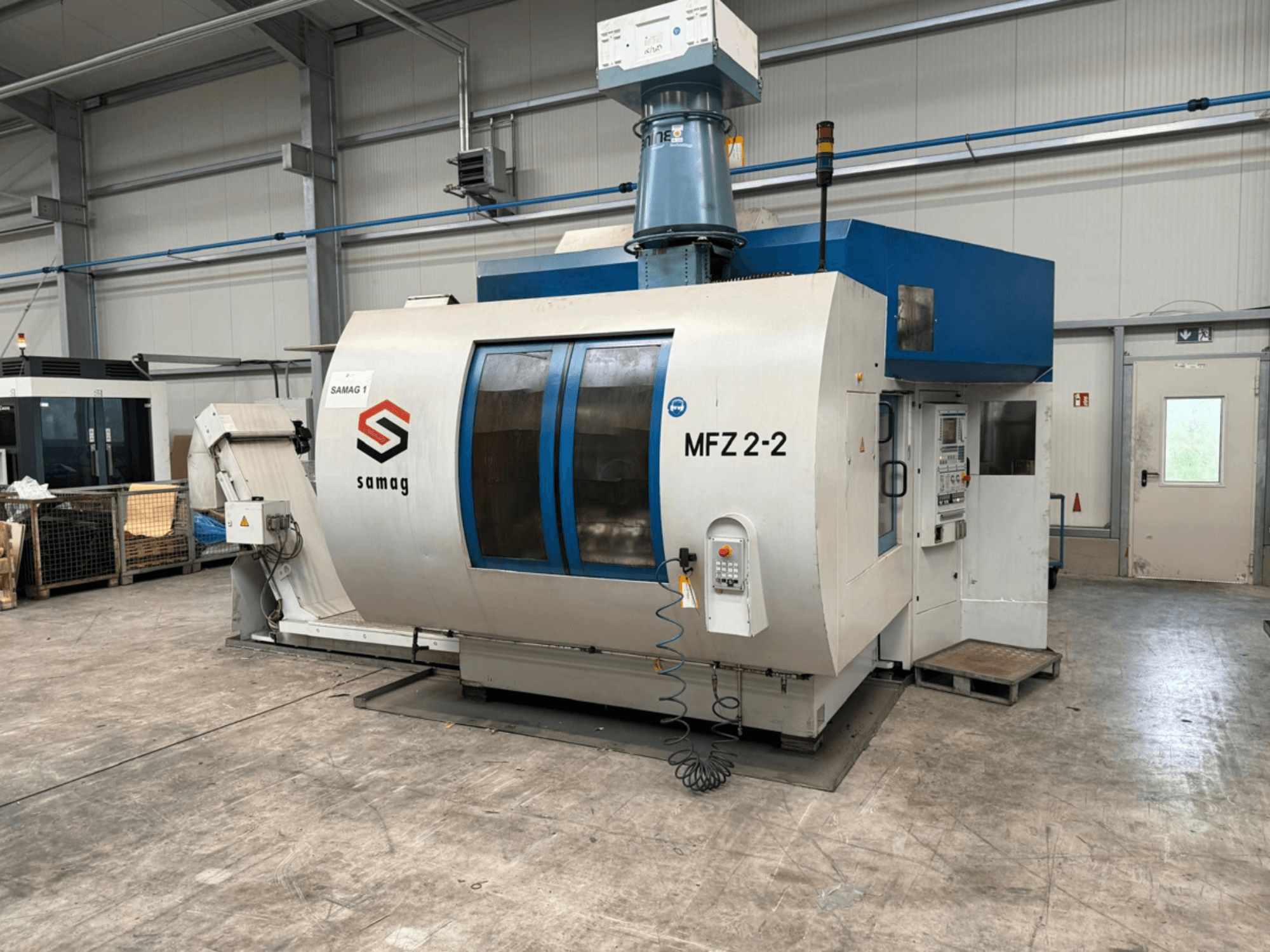 Верстат Samag MFZ 2-2, вид спереду, з панеллю керування і синім верхом, з функціями безпеки в промислових умовах.