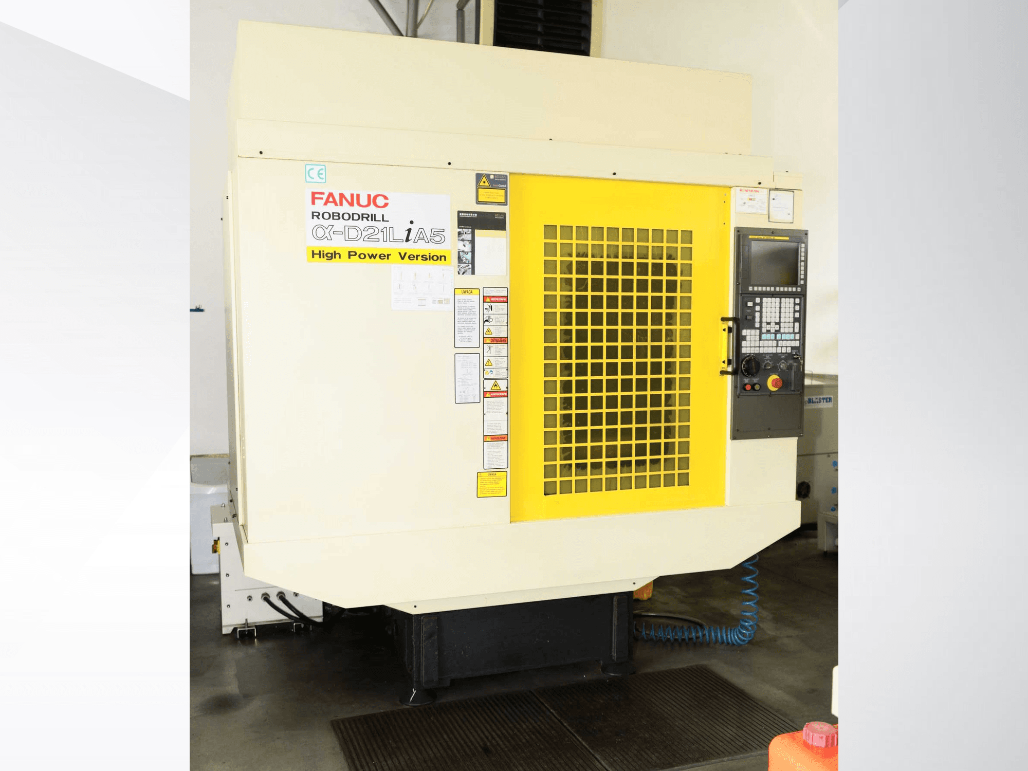 Вертикальний обробний центр FANUC ROBODRILL α-D21LiA5, вид спереду з жовтою захисною решіткою та деталями панелі керування.
