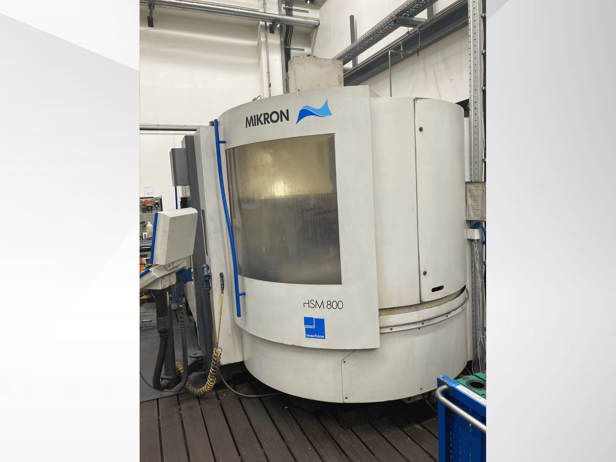 Верстат з ЧПК Mikron rISM 800, вид спереду з панеллю керування, циліндричний дизайн і сині акценти, встановлений у майстерні.