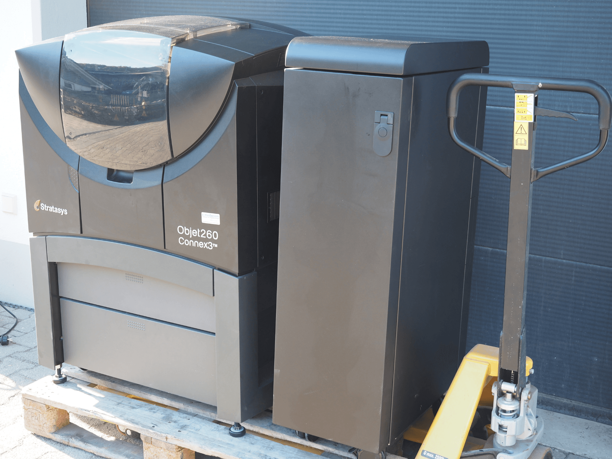 Пластиковий 3D-принтер Stratasys Objet260 Connex3, вид збоку, має компактну конструкцію з панеллю керування та підключеним бункером для матеріалів.