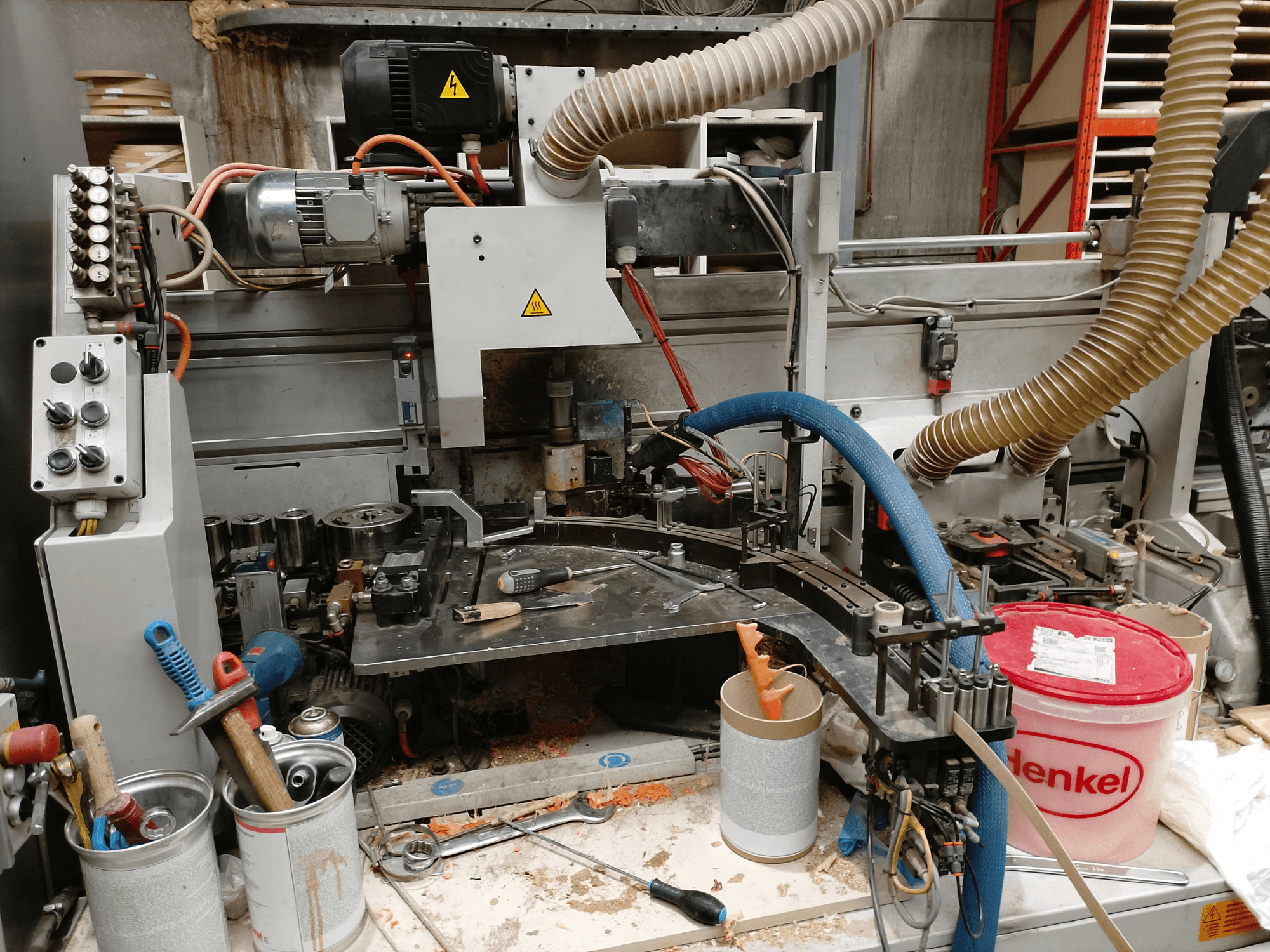 Кромкооблицювальний верстат BIESSE Edge Stram B1 спереду, демонструє машини, шланги та робочі інструменти серед деревної стружки.