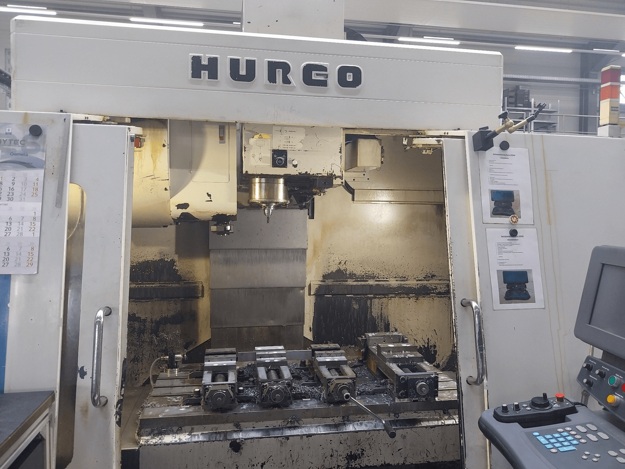 Вертикальний обробний центр Hurco VMX 42, вид спереду, показує робочий стіл з кріпленнями та панеллю керування, злегка зношений стан.