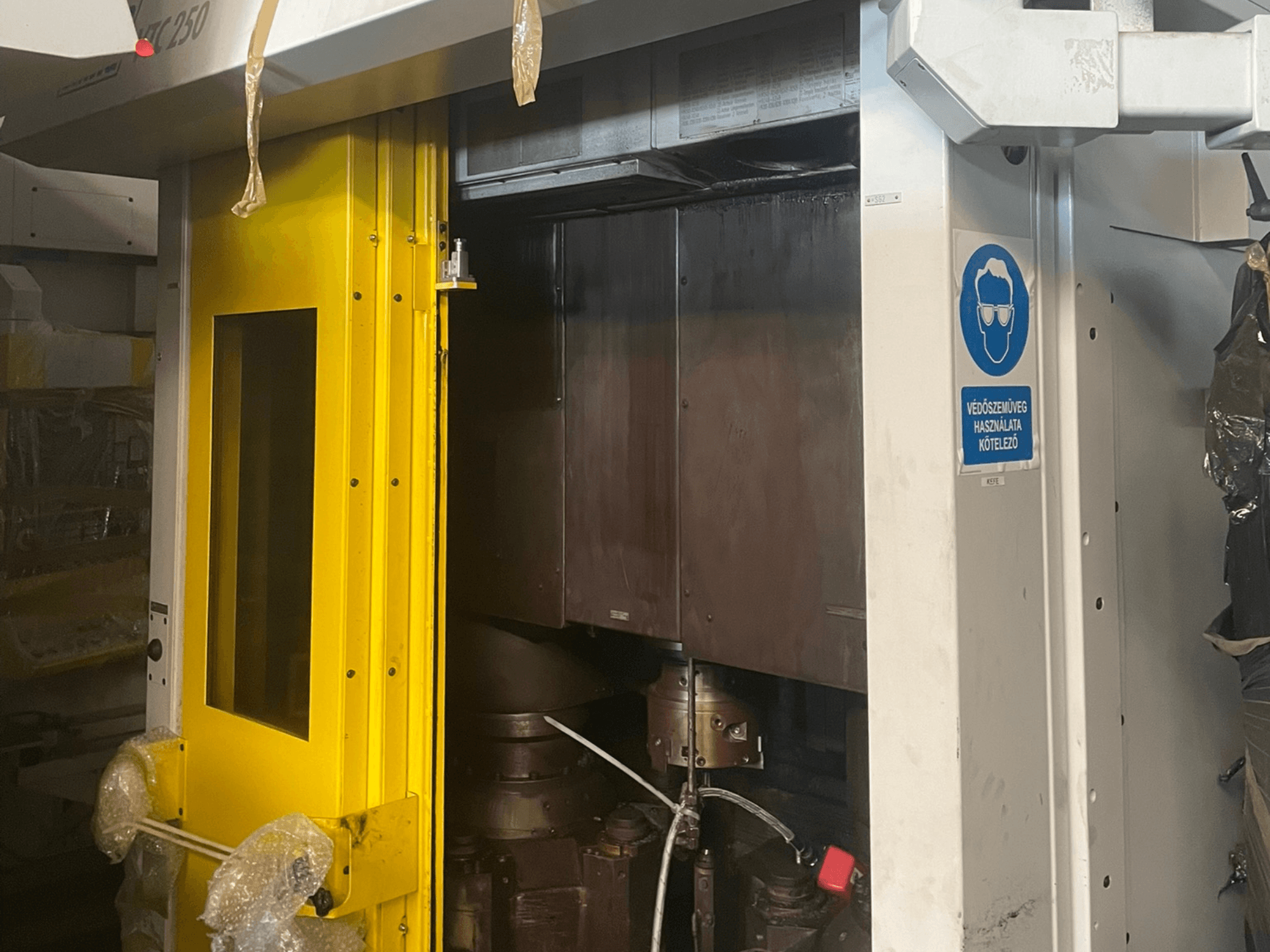 Жовті вхідні двері верстата зі знаком безпеки, вид спереду промислового верстата моделі Z250, що демонструє внутрішні компоненти.