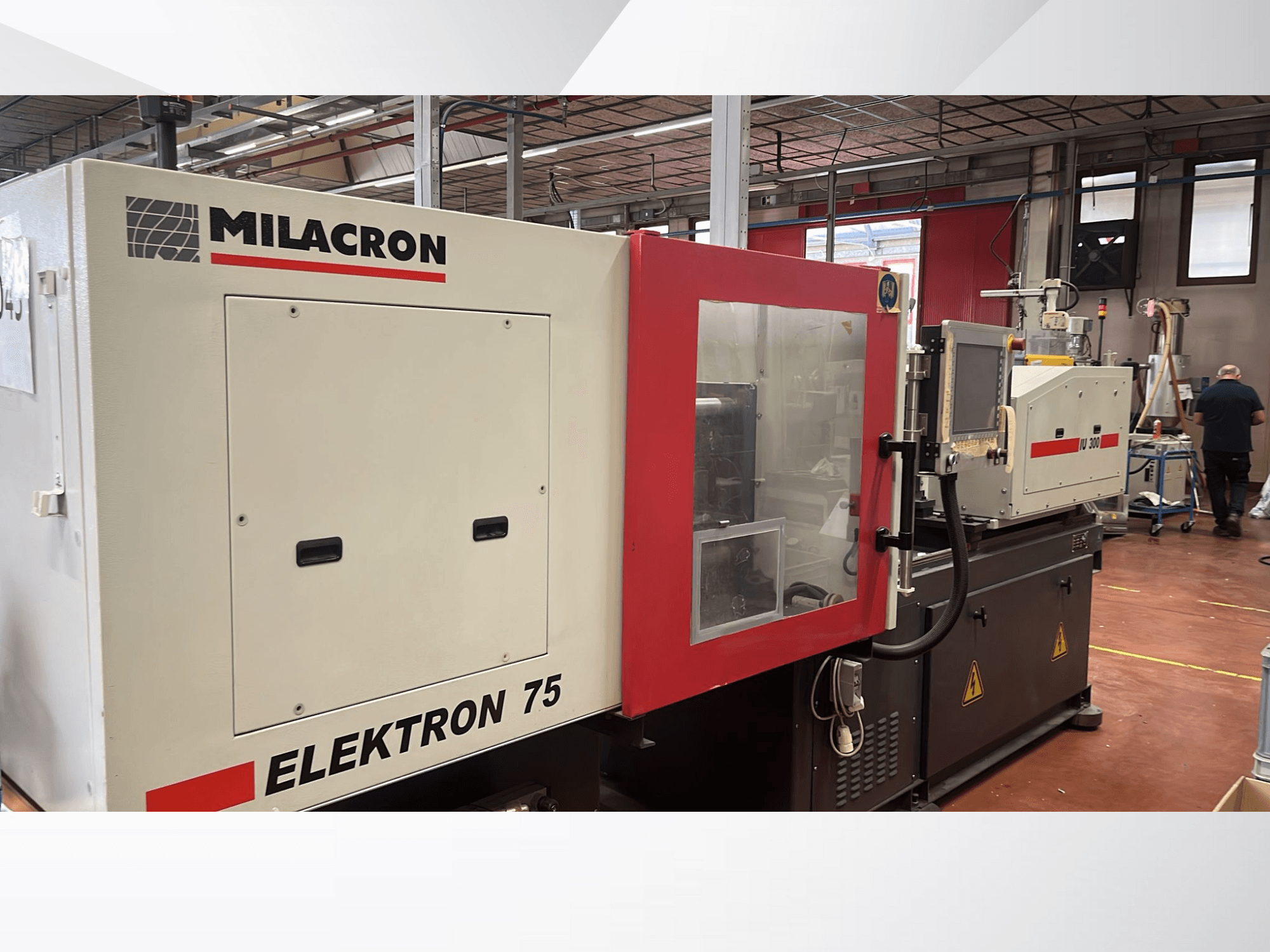Термопластавтомат Milacron Elektron 75 в умовах майстерні, вид збоку, що демонструє панель керування та механічні частини.