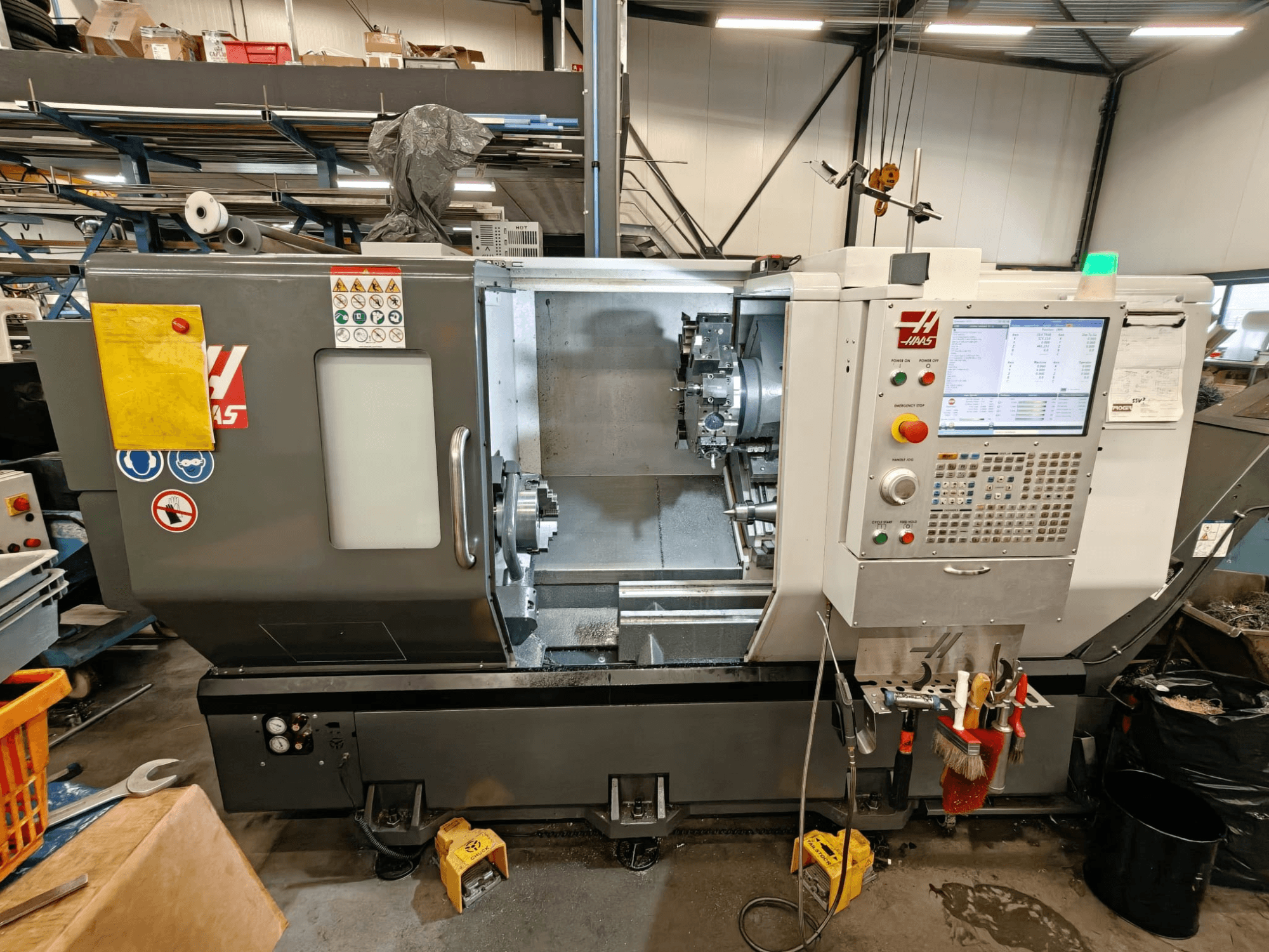 Горизонтальний токарний верстат HAAS ST-25Y, вид спереду, з панеллю керування, місцем для зберігання інструменту та робочою установкою в майстерні.