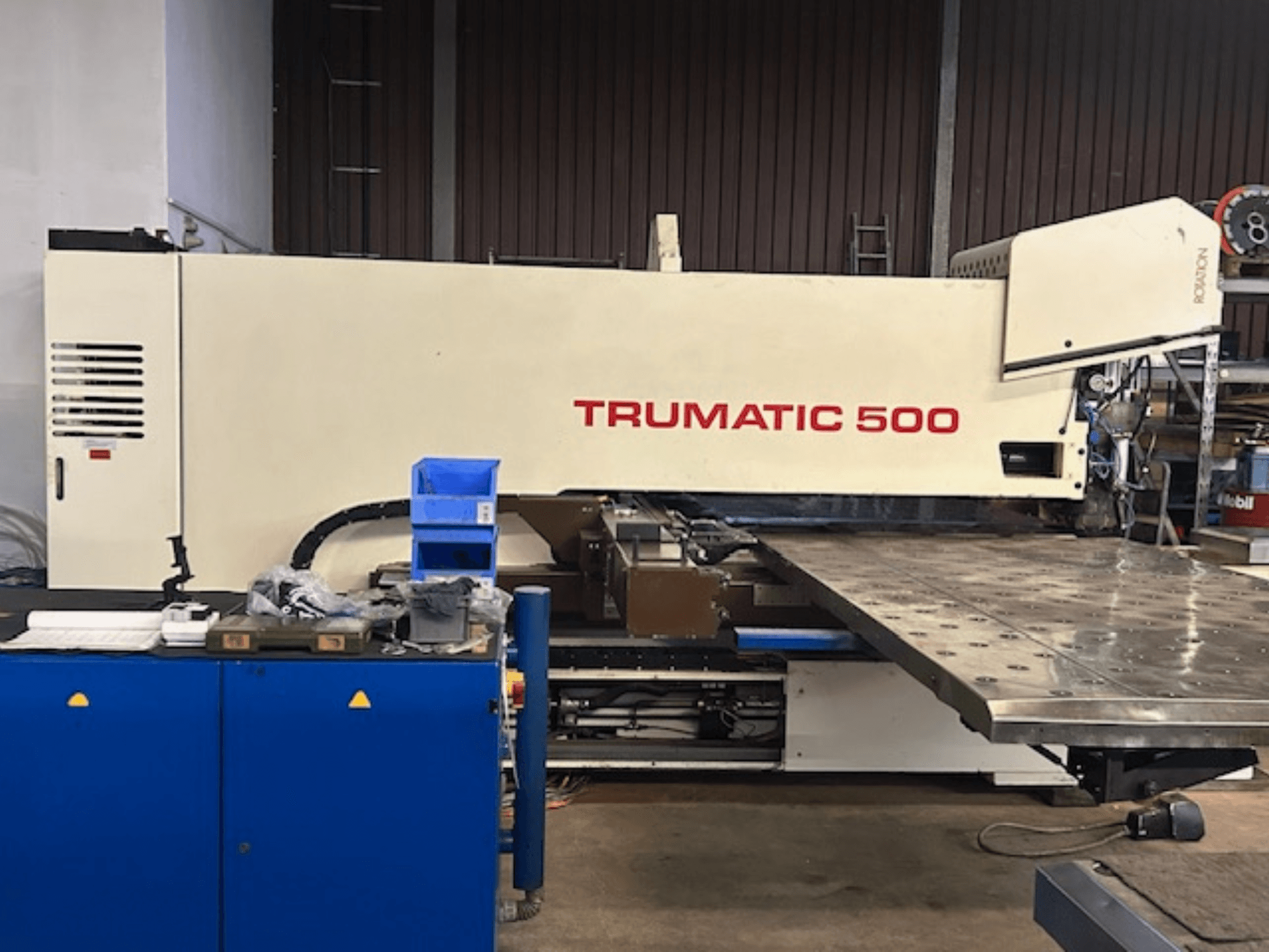Перфоратор TRUMPF TRUMATIC 500 з ЧПУ, вид спереду, з панеллю керування та великим робочим столом з перфорованою поверхнею.