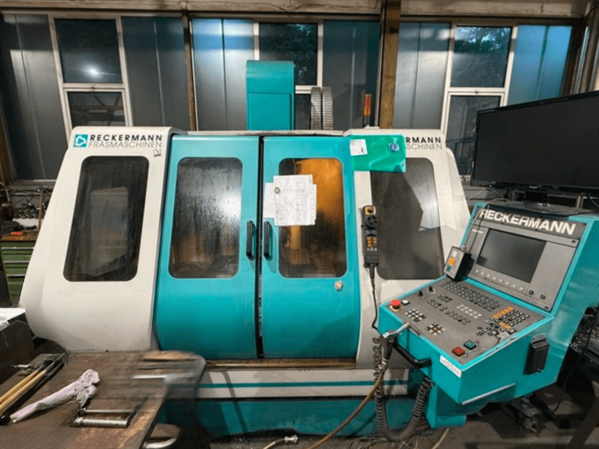 Універсальний обробний центр RECKERMANN VMC 850, вид спереду з панеллю керування та скляними дверцятами.