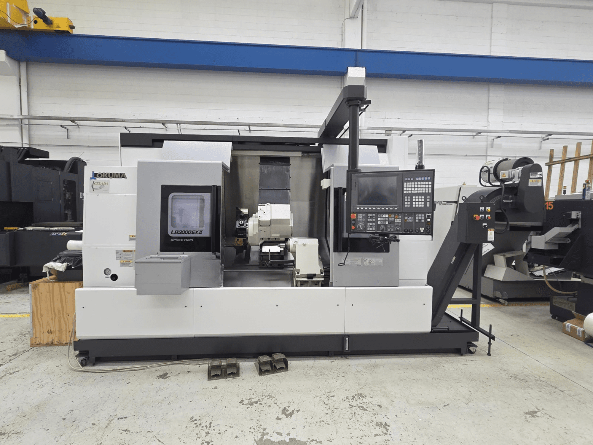 Горизонтальний токарний верстат Okuma LB 3000 EXII показаний спереду, з панеллю керування та тримачем інструменту.