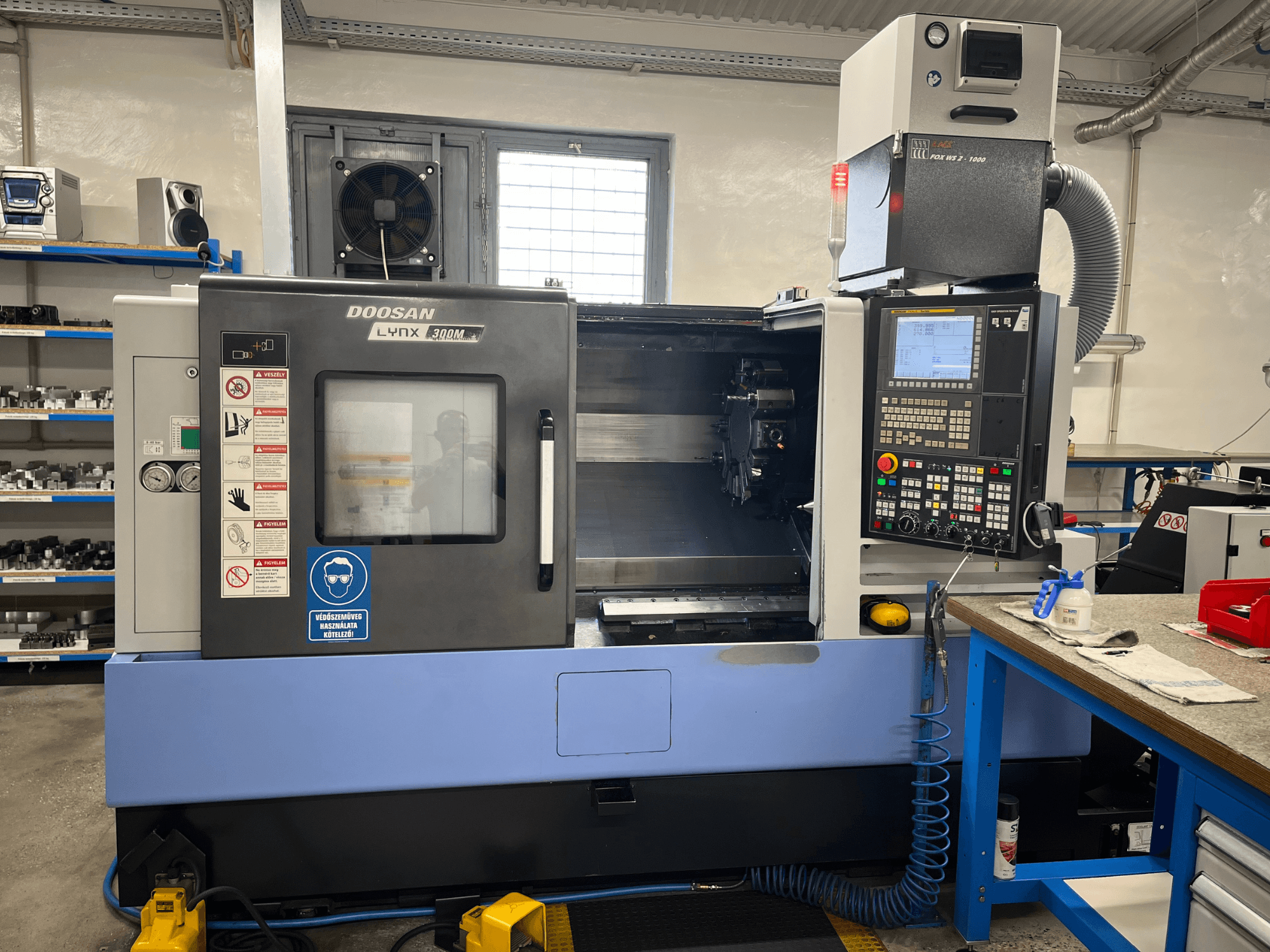 Горизонтальний токарний верстат DOOSAN LYNX 300M, вид спереду, з панеллю керування та робочими елементами.